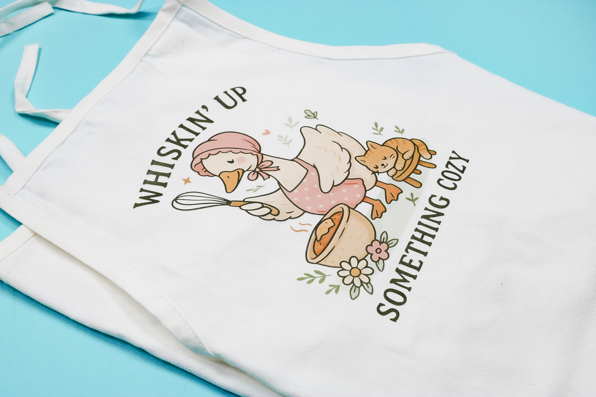 DTF child apron with HTVRont A100 heat press.