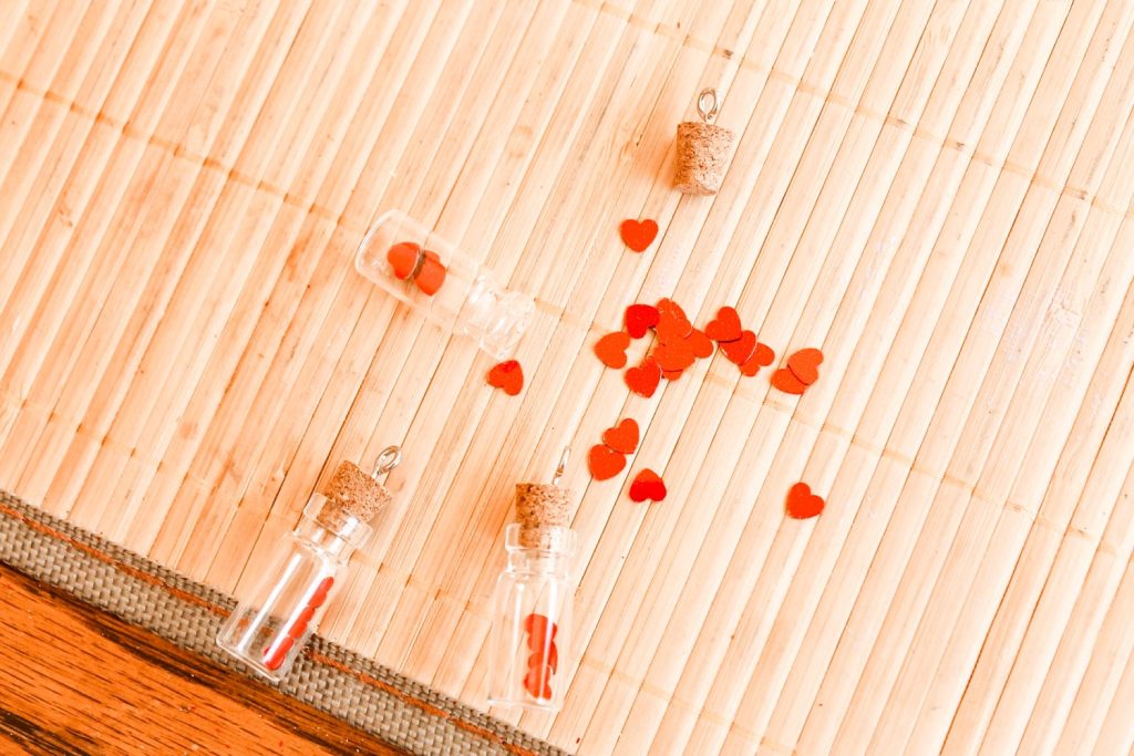 adding heart confetti to a tiny jar