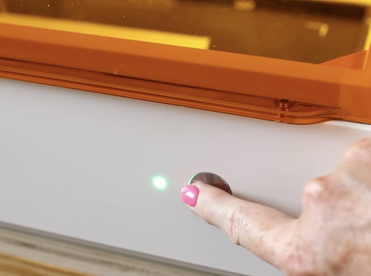 Press the start button on the front of the laser.