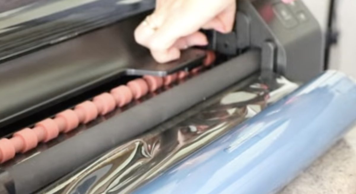 Open the rollers to remove the film from the laminator.