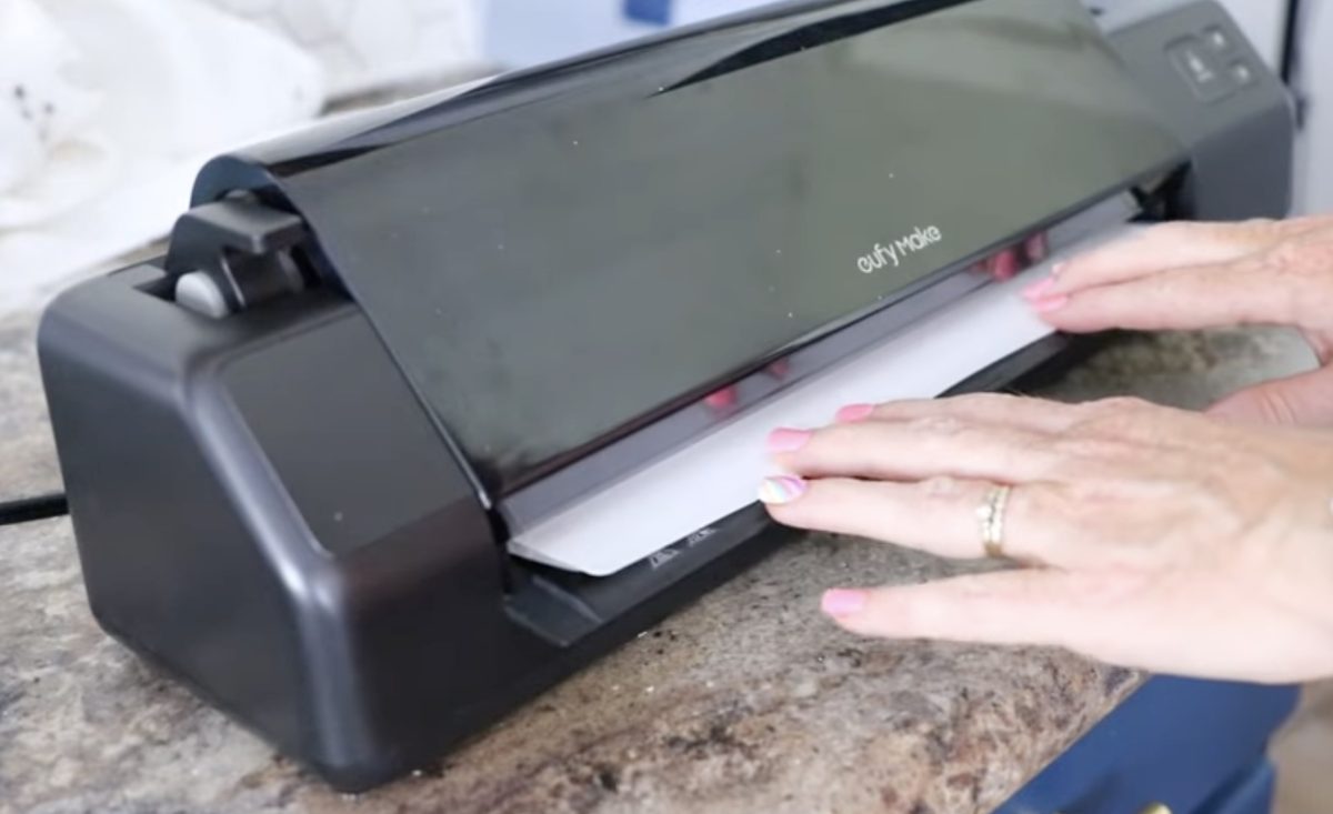 Use the white piece to feed the foil through the laminator.