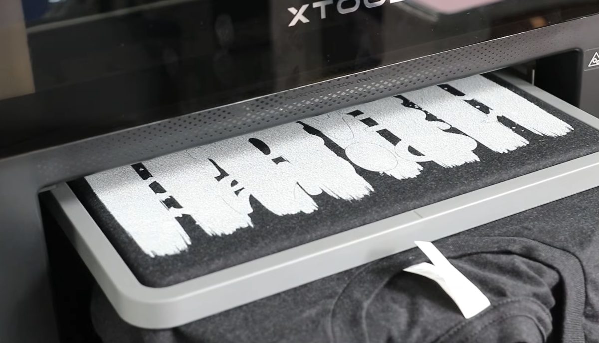 xTool Omni printing white directly on a black shirt.
